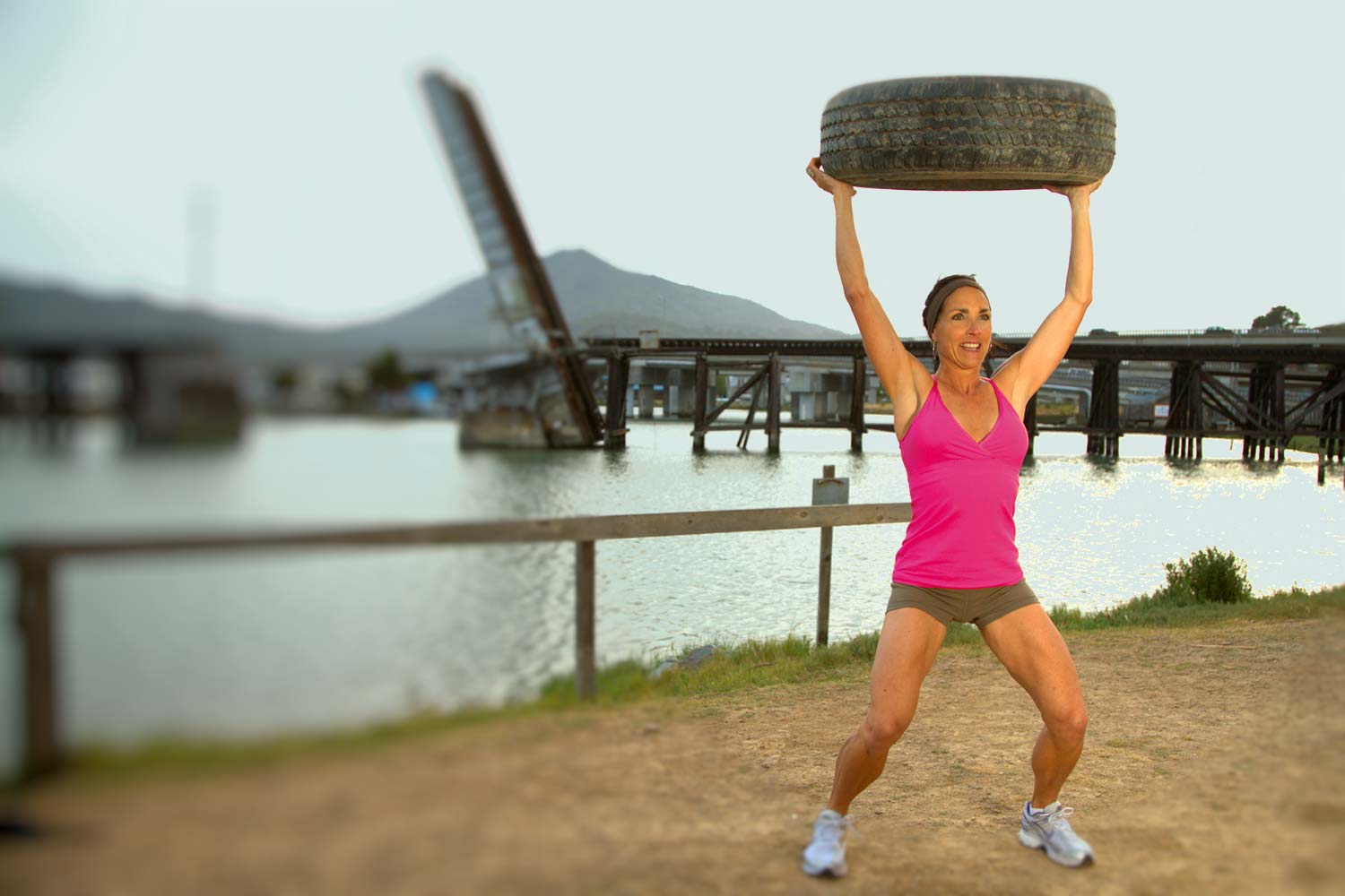 Beyond Fitness creator Michele Vaughan shows her strength and technique while lifting a tire overhead