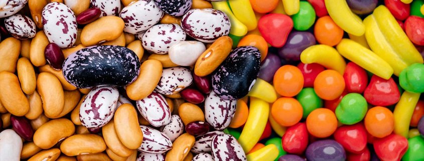 Close up view of a pile of beans on the left side, composited with a pile of candies on the right.